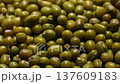 Close-up sequence of green mung beans showcasing their texture and color variations on a surface, highlighting the natural beauty of these legumes in a detailed view 137609183