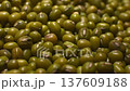 Close-up sequence of green mung beans showcasing their texture and color variations on a surface, highlighting the natural beauty of these legumes in a detailed view 137609188