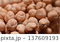 Close-up sequence of dried chickpeas in a glass container, showcasing their texture and color variations, with a blurred background emphasizing the focus on the legumes 137609193