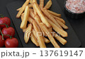 French fries, a salty, crispy, homemade snack with spices. French fries on a black background 137619147