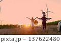 Family with son walking on field on wind farm.  137622480