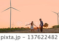Family with son walking on field on wind farm.  137622482