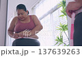 Plus size asian woman measuring waist with tape with mirror at home, weight loss and body positive. 137639263