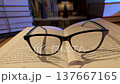 Eyeglasses resting on open book with stacks creating study atmosphere 137667165