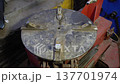 Metal disk on a red machine in a workshop used for various tasks during a work session 137701974