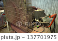 Air compressor in a workshop setting, showing dust and usage marks in a working environment during the day 137701975