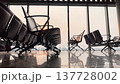 Airport terminal features rows of modern seating illuminated by warm sunrise light, creating a tranquil environment for waiting passengers 137728002