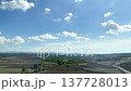 Rolling hills and farmland in Turkey display lush greenery and a bright blue sky with clouds, highlighting the serene landscape and agricultural richness 137728013