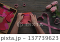 Woman Hand Putting Valentine Card into Pink Envelope Top View DIY Craft 137739623