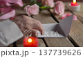 Man Hand Putting Valentine Card into White Envelope on Wood Table Close Up 137739626
