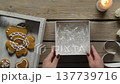 Women Hands Putting White Iced Gingerbread Hearts in Gift Box Top View 137739716