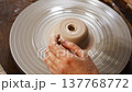 Working on a pottery wheel to create a clay bowl in a studio 137768772