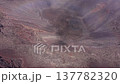 Drone footage ascending above a volcanic crater at Piton de la Fournaise Reunion Island.Fog moves across the scene,revealing and obscuring sections of the crater 137782320