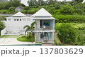 Woman standing on modern villa balcony, holding a cup of coffee and looking out at tropical landscape, enjoying peaceful morning during her vacation in Bali, Indonesia. Aerial flight zoom out panorama Woman standing on modern villa balcony, holding a cup of coffee and looking out at tropical landscape, enjoying peaceful morning during her vacation in Bali, Indonesia. Aerial flight zoom out panorama 137803629