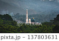 Lombok, Sembalun mosque, featuring a prominent minaret and green dome, stands amidst lush forested mountains, symbolizing the Islamic faith within the stunning natural landscape of Indonesia Lombok, Sembalun mosque, featuring a prominent minaret and green dome, stands amidst lush forested mountains, symbolizing the Islamic faith within the stunning natural landscape of Indonesia 137803631