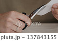 Close Up of Scissors Cutting Paper Sheet 137843155