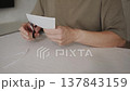 Man Beginning to Cut White Paper with Scissors 137843159