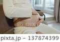 A pregnant woman massages her belly with her hands. Close-up. Circular abdominal massage to soothe the baby in the womb. Gentle care and stroking of the abdomen. Stretch mark prevention. 137874399