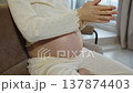Pregnant woman with large belly in her seventh month of pregnancy strokes her belly with her hands. Close-up of hands applying cream to her belly to combat stretch marks in late pregnancy. 137874403