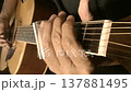 Close-up shot of an individual playing glass slide on an acoustic guitar. The scene has old sepia film look.  137881495