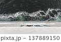Top view from a ship deck on dark sea water with white foam waves 137889150