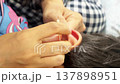 INCHEON, SOUTH KOREA - MARCH 17, 2026: Close-up of a Mother's Hand Carefully Cleaning Her Child's Ear with a Cotton Swab 137898951