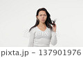 Young woman in an isolated space with problematic dry hair white background 137901976