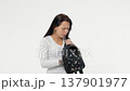 Nervous adult woman in casual clothing searching some lost thing in black purse, trying to find keys or some object 137901977