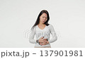 Woman had a stomach ache stomach and squeezed it to relax and soothe female menstrual cramps on isolated white background 137901981