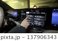 A driver uses a touchscreen in a modern car. 137906343