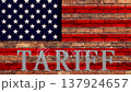 A cinematic stock video featuring a distressed, weathered brick wall with a faded American flag painted directly onto the surface. The word "TARIFF" appears in  heavy concrete 3D lettering. The t 137924657