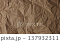 Stop motion animation of various crumpled kraft paper sheets in natural brown, ochre, and earthy terracotta tones. This recycled eco material showcases a rough vintage texture. 137932311