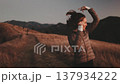 A woman enjoys her time outdoors in the Carpathian Mountains at sunset, surrounded by stunning natural landscapes and rolling hills. 137934222