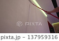 Person painting wall with white roller 137959316