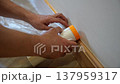 Man applying protective tape along baseboard 137959317