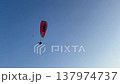 Paraglider flying high in clear blue sky. Extreme sport and freedom concept with copy space. Adventure travel and outdoor activity in summer. 137974737