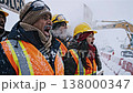Workers ask safety. Snowcovered construction workers advocate for safety improvements. Excavator crew wearing protective gear insist on better safety protocols amid winter conditions 138000347