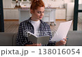 Smiling joyful Caucasian woman designer at home choosing colorful palette apartment renovation writing ideas notebook couch female looking camera planning interior design creative decor girl project 138016054