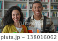 Multiethnic smiling couple students at university happy Indian Arabian woman African American man looking at camera classmates library holding books college study learning education girl guy academy 138016062