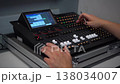 Man operating professional lighting mixer and adjusting settings with stylus 4k 138034007