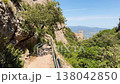 Walking in the mountains of Montserrat in Spain in summer. Panorama of mountain peaks and green plants against the blue sky. Trails for active recreation 138042850