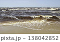 Sandy coastline of the Baltic Sea in Latvia. Yellow sand and large stones on the shore. Waves run onto the beach on a sunny day. Latvia, Gulf of Riga.  138042852