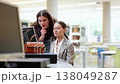 Female student helping female student work on computer  138049287