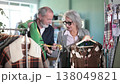 Elderly married couple chooses fashionable warm dress and sweater in clothing store 138049821