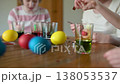 Two big sisters and their little brother dyeing Easter eggs at home. Slow motion 138053537