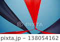 abstract view of red and black triangle shaped cloth decoration waving by wind on blue sky background. summer sea camp or beach club decoration, vibrant colors 138054162