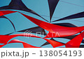 abstract view of red and black triangle shaped cloth decoration waving by wind on blue sky background. summer sea camp or beach club decoration, vibrant colors 138054193