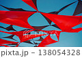 abstract view of red and black triangle shaped cloth decoration waving by wind on blue sky background. summer sea camp or beach club decoration, vibrant colors 138054328