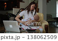 Stressed multitasking mother working from home holding a baby 138062509
