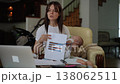 Working mother discussing charts during video call while holding sleeping baby 138062511